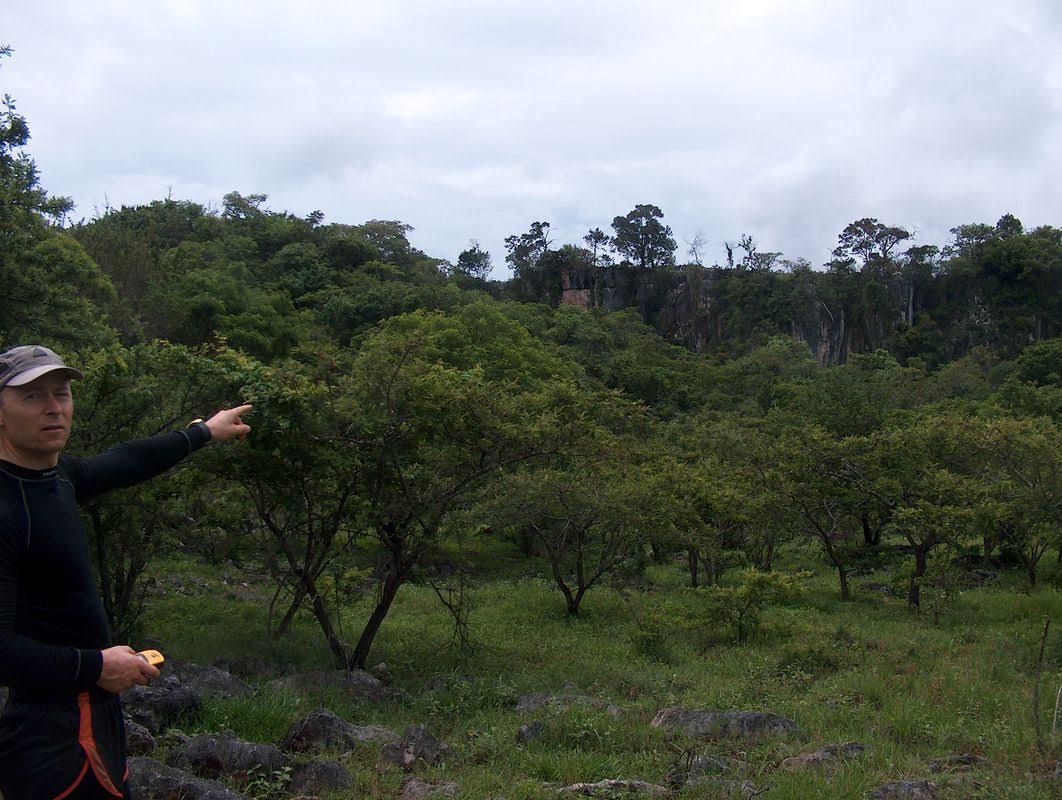 Torben Redder peger op på tempelbyen over de lodrette klipper.jpg